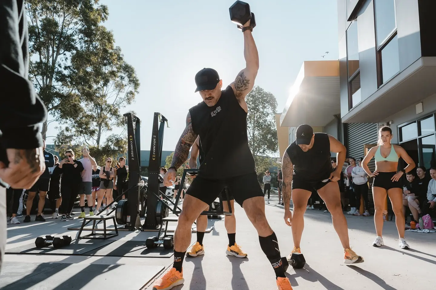 A member pressing a dumbbell overhead