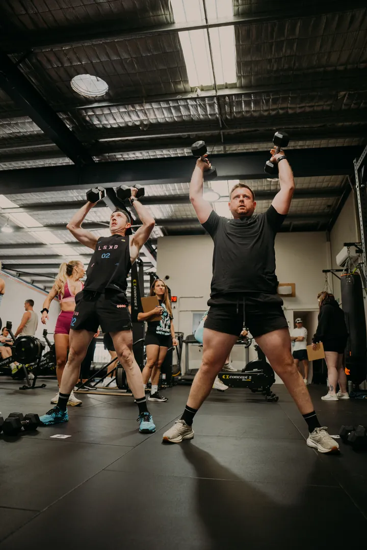 Members pressing dumbbells overhead