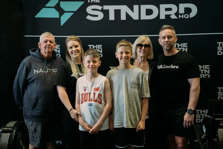 A family in front of the STNDRD sign